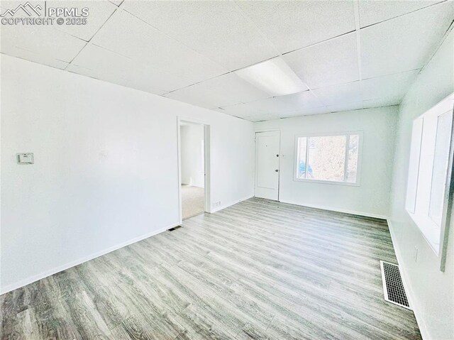 1108 W 16th St, Pueblo, CO 81003 - spare room with a paneled ceiling, visible vents, baseboards, and wood finished floors