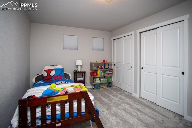 carpeted bedroom featuring two closets
