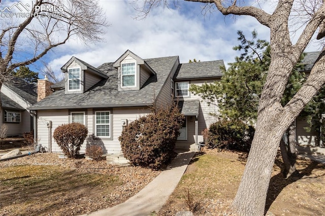 new england style home featuring roof with shingles