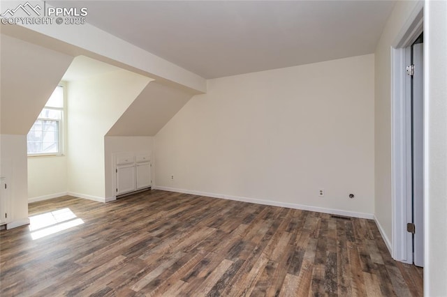 additional living space with lofted ceiling, baseboards, and wood finished floors