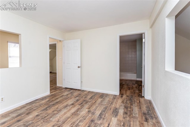 unfurnished bedroom with baseboards and wood finished floors