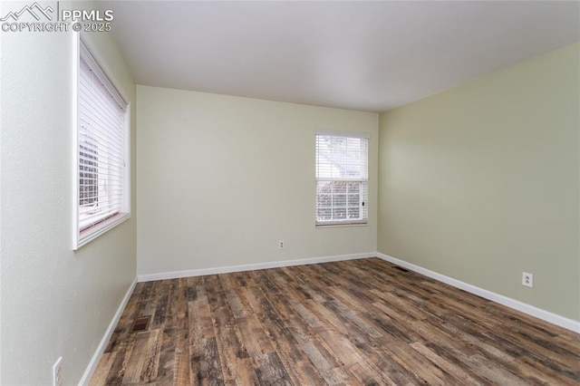 unfurnished room with visible vents, baseboards, and wood finished floors