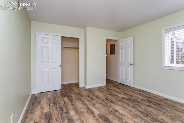 unfurnished bedroom with a closet, baseboards, and wood finished floors