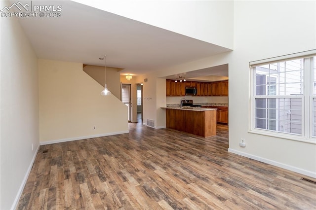 unfurnished living room featuring dark wood-style flooring, visible vents, and baseboards