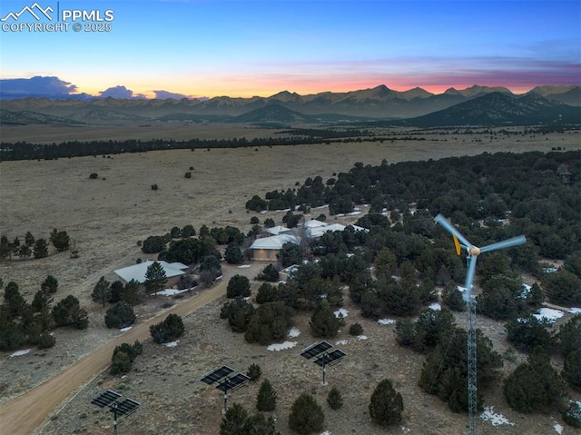 aerial view at dusk featuring a mountain view and a rural view