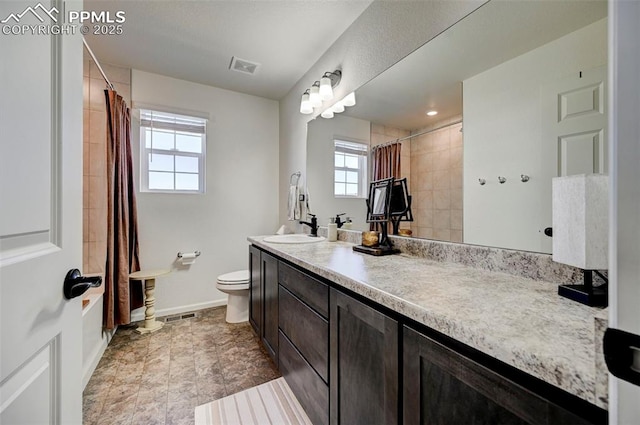 bathroom featuring visible vents, toilet, vanity, and baseboards