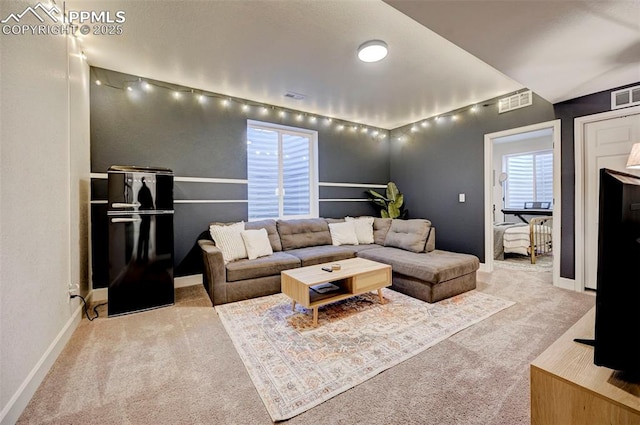 living area featuring carpet, visible vents, and baseboards