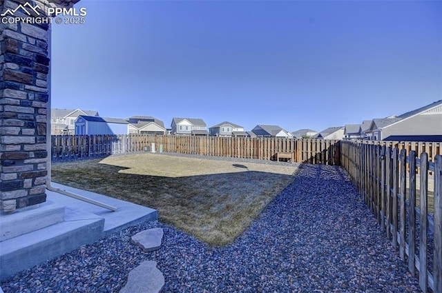 view of yard with a fenced backyard and a residential view