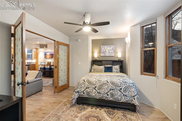 bedroom featuring visible vents, ceiling fan, and light wood-style flooring