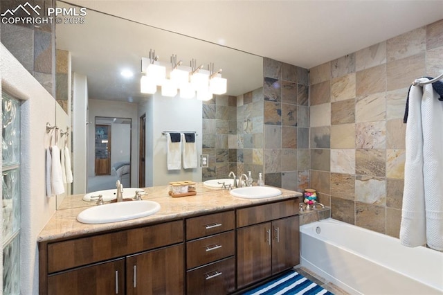 bathroom featuring double vanity, ensuite bath, a sink, and a bath