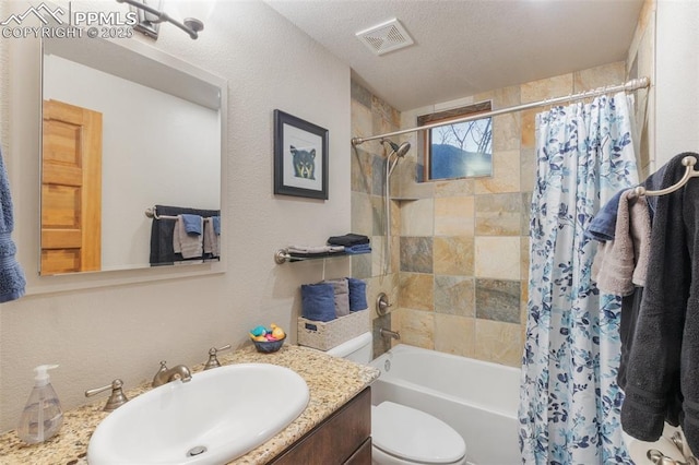 full bathroom featuring visible vents, toilet, shower / tub combo with curtain, a textured ceiling, and vanity