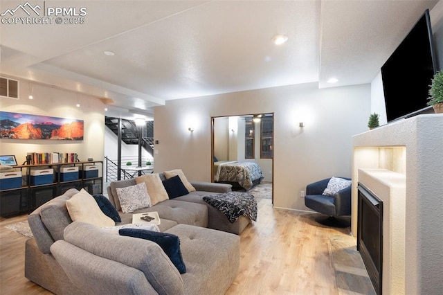 living area featuring light wood-type flooring and recessed lighting