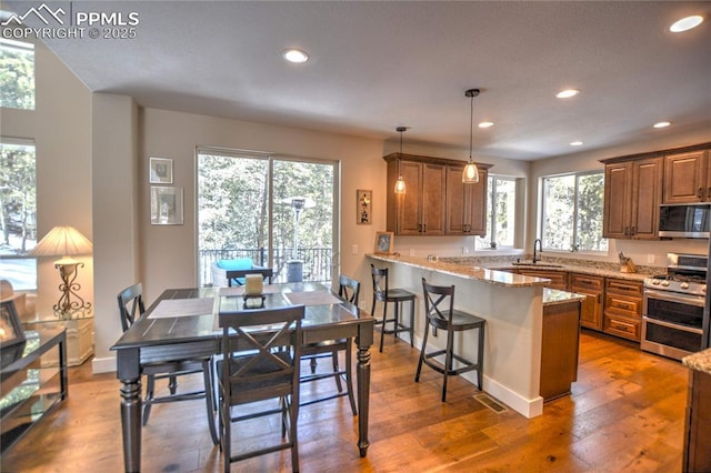 kitchen with brown cabinets, stainless steel appliances, and a sink