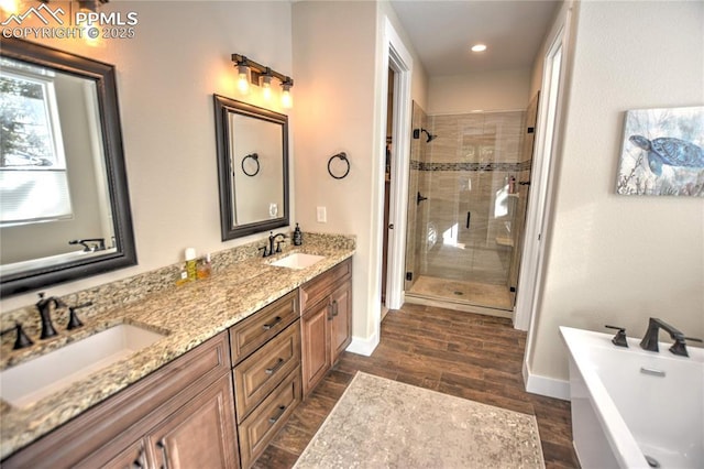 full bath with a stall shower, baseboards, a sink, and a soaking tub