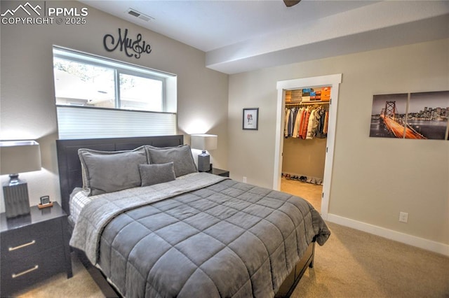 bedroom featuring visible vents, baseboards, a closet, carpet, and a walk in closet