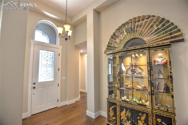 entryway featuring a notable chandelier, plenty of natural light, baseboards, and wood finished floors