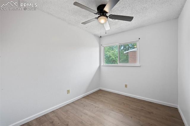 spare room with ceiling fan, a textured ceiling, baseboards, and wood finished floors