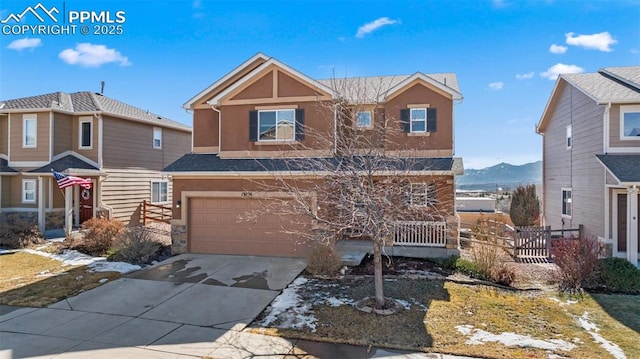 view of front facade featuring driveway, an attached garage, fence, and stucco siding