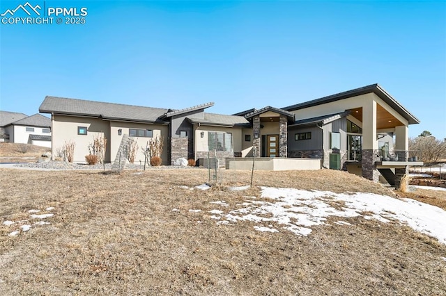 view of front facade featuring stone siding and stucco siding