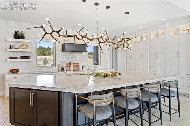 kitchen featuring glass insert cabinets, white cabinets, a large island, and open shelves