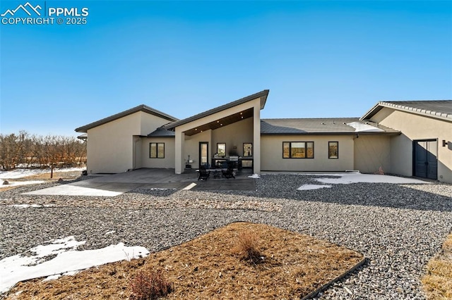 back of property featuring a patio area and stucco siding