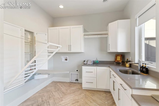 kitchen with recessed lighting, white cabinetry, a sink, and baseboards