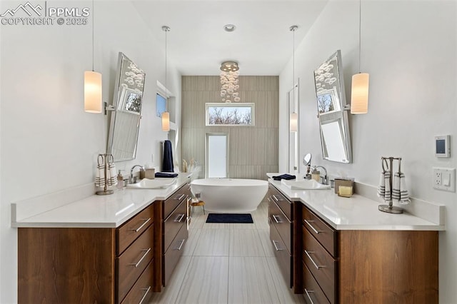 bathroom featuring a freestanding tub, vanity, and tile patterned floors