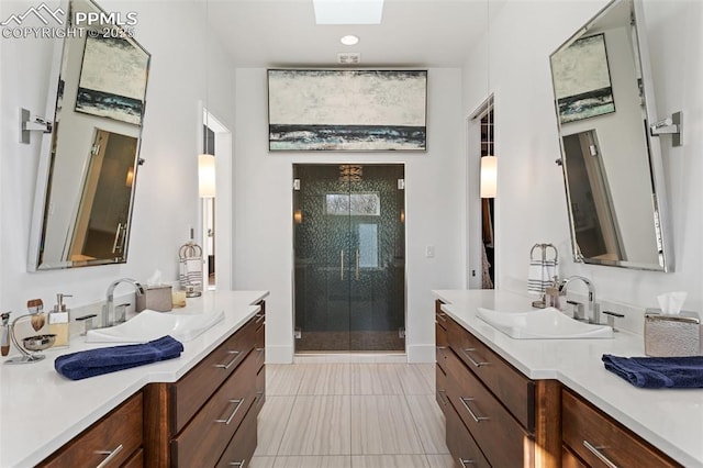 full bath featuring a shower stall, two vanities, and a sink