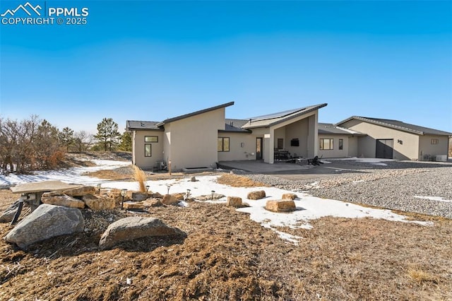 rear view of property featuring a patio and stucco siding