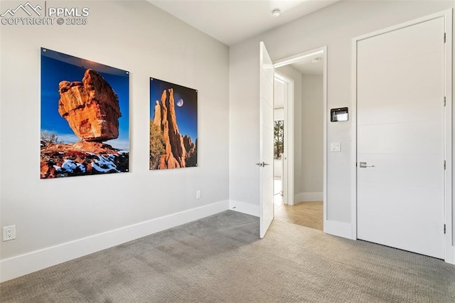 interior space featuring light carpet and baseboards