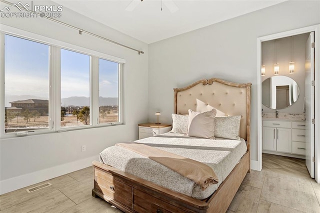 bedroom with baseboards, visible vents, connected bathroom, light wood-type flooring, and a mountain view