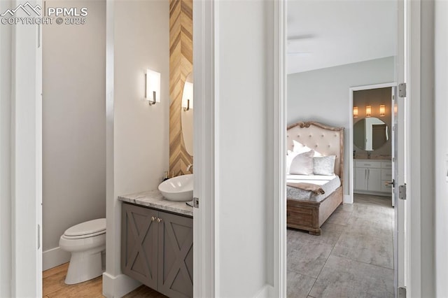 bathroom with toilet, ensuite bath, and vanity