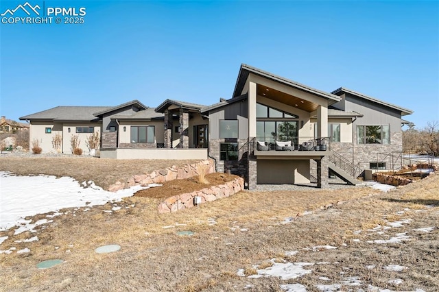 view of front of house featuring stucco siding and stairs