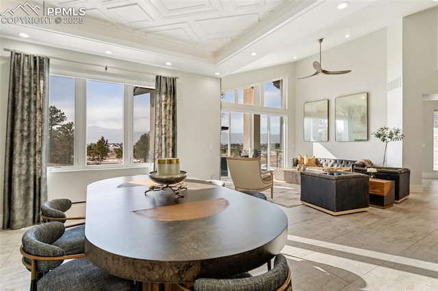 dining room with a tray ceiling, a high ceiling, and recessed lighting