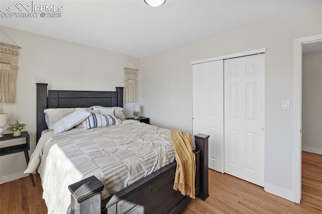 bedroom featuring a closet, baseboards, and wood finished floors