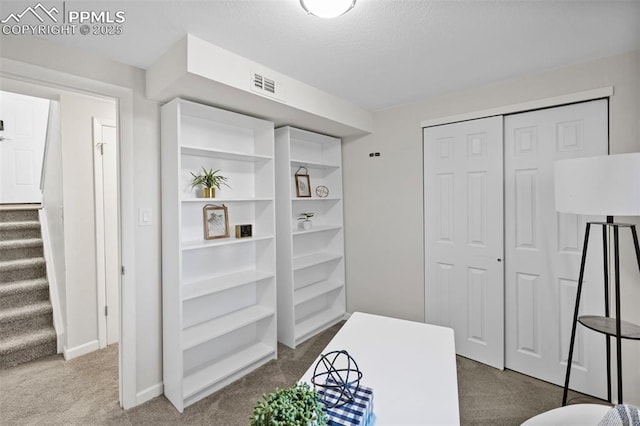 interior space featuring a closet, visible vents, and carpet flooring