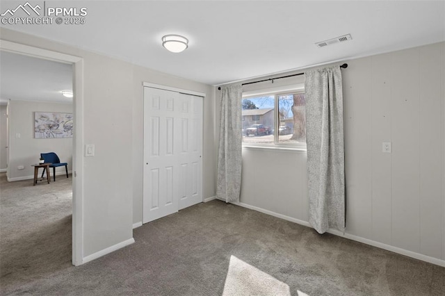 unfurnished bedroom with baseboards, carpet, visible vents, and a closet