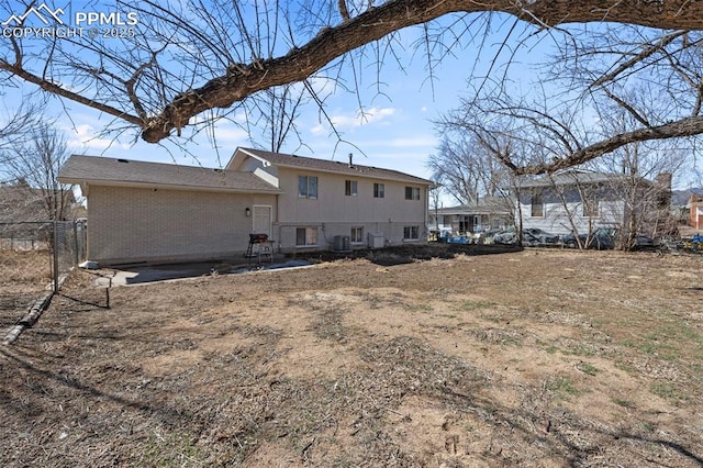 back of property with a patio, brick siding, cooling unit, and fence