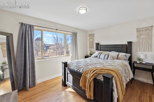 bedroom with baseboards and wood finished floors