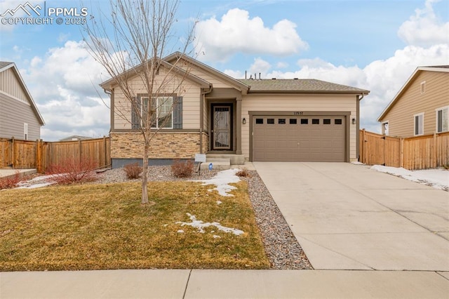 single story home with an attached garage, fence, concrete driveway, stone siding, and a front yard