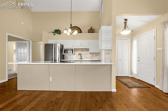 kitchen featuring dark wood-style floors, appliances with stainless steel finishes, light countertops, white cabinetry, and a sink