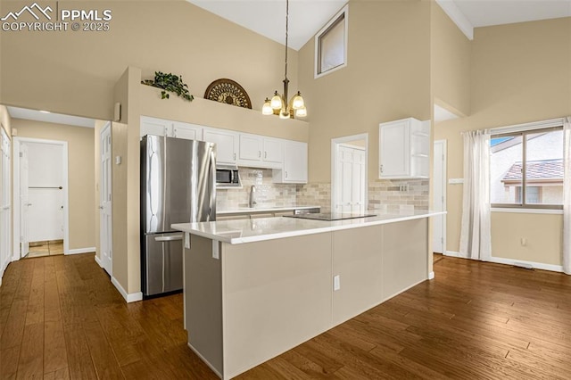 kitchen featuring light countertops, appliances with stainless steel finishes, dark wood-type flooring, and white cabinets