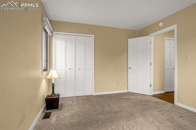 unfurnished bedroom featuring baseboards, a closet, visible vents, and carpet flooring