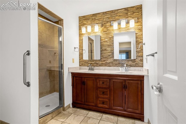 bathroom featuring a shower stall, a sink, and decorative backsplash