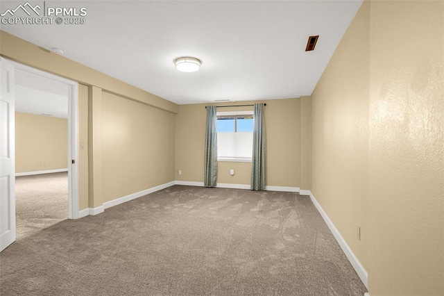 spare room featuring baseboards and carpet flooring