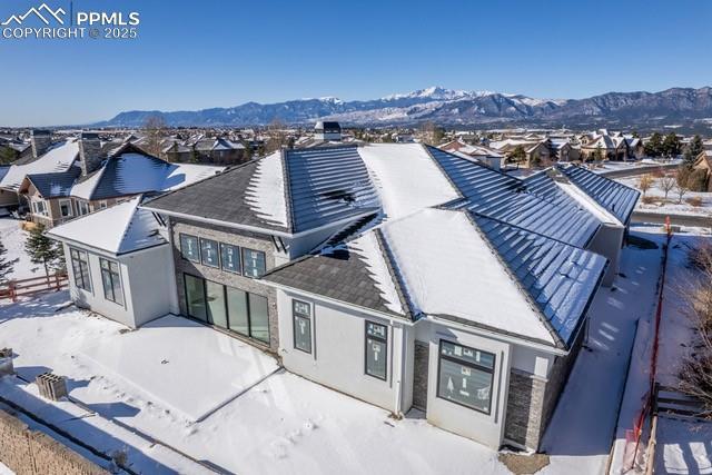 snowy aerial view with a residential view and a mountain view