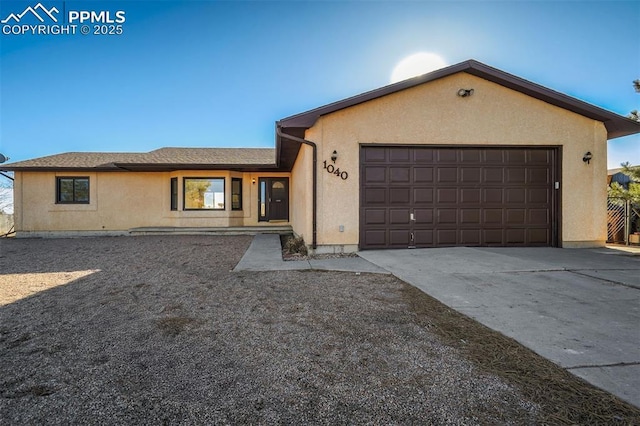 ranch-style house featuring a garage, concrete driveway, and stucco siding