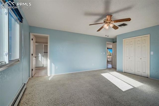 unfurnished bedroom featuring ceiling fan, baseboards, visible vents, and baseboard heating