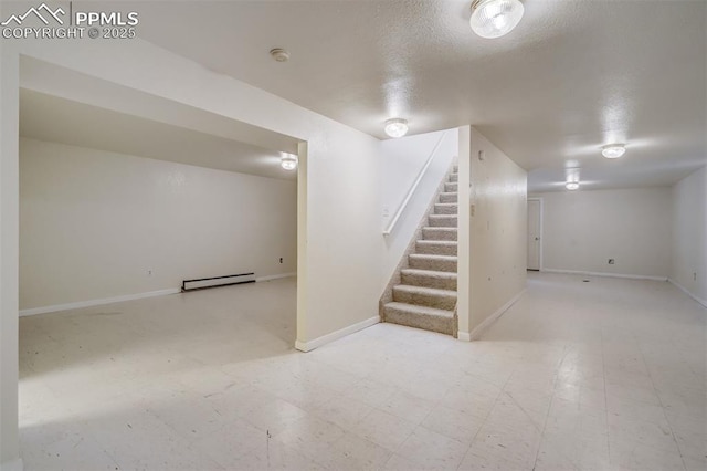 finished below grade area featuring light floors, stairway, a baseboard heating unit, a textured ceiling, and baseboards