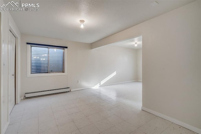 unfurnished room with a baseboard heating unit, baseboards, and light floors